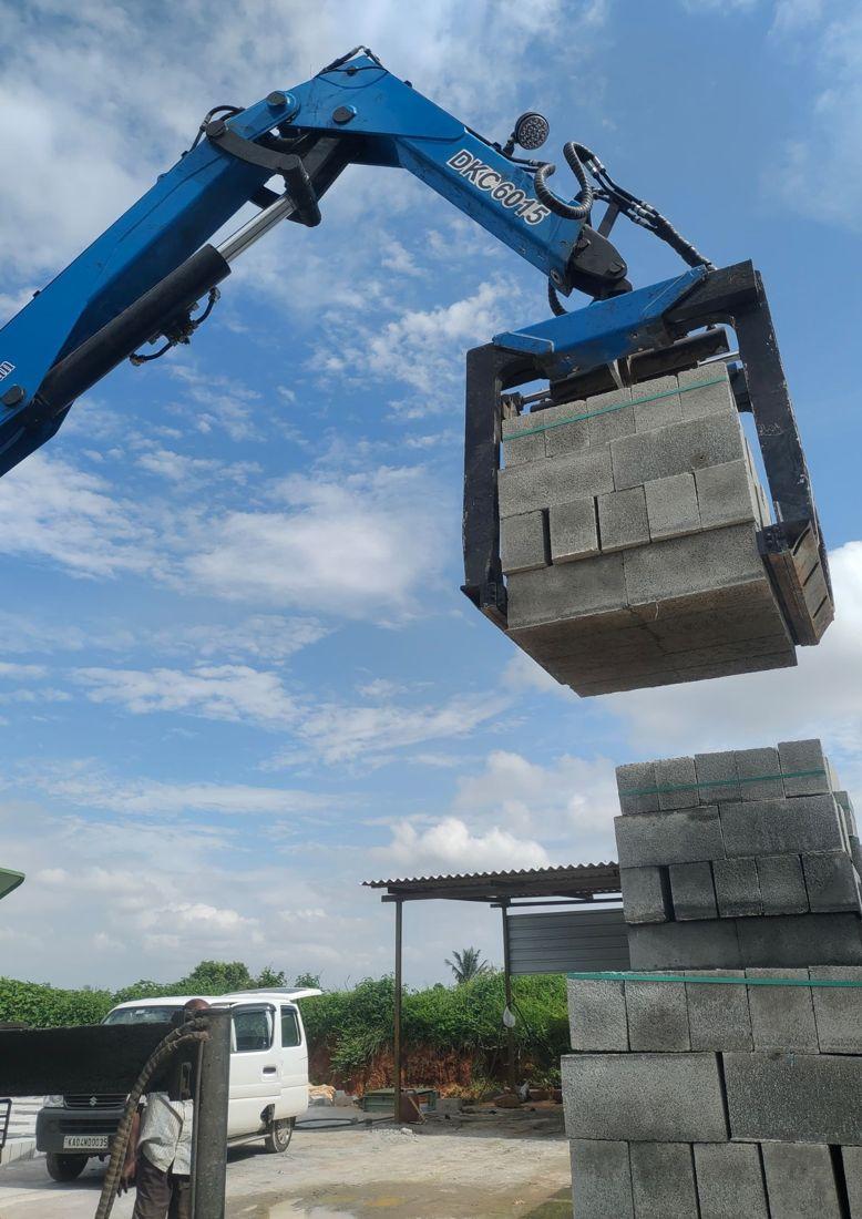 Truck-mounted crane with brick grabber lifting blocks