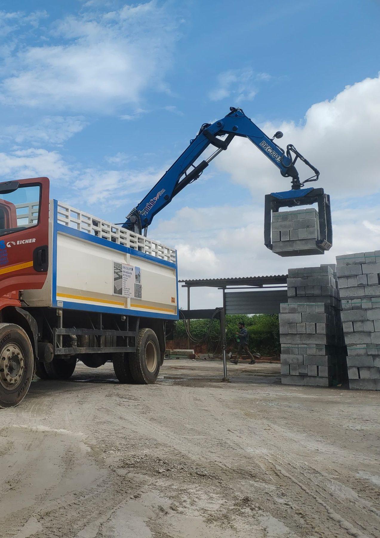 SAE 04 crane grabber unloading blocks from a truck