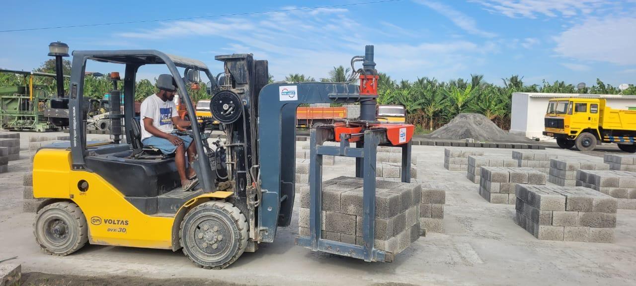 Forklift carrying a stack of hollow blocks with the SAE 01 brick grabber