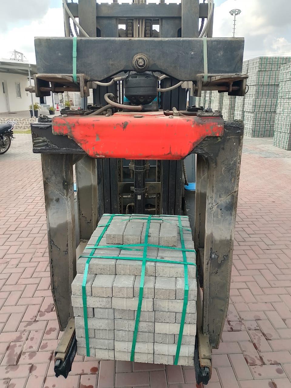 SAE 02 brick grabber holding strapped pavers on a forklift
